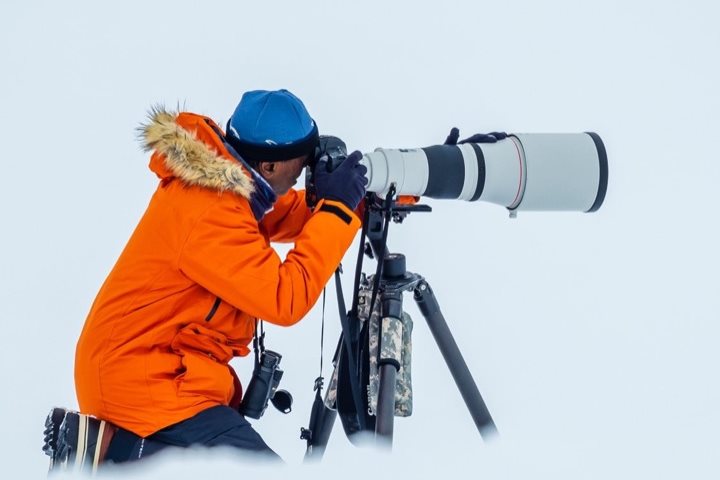 A man using a long lens to photograph polar landscape
